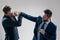 two angry businessmen punching in fight because of business competition, business knockout.