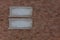 Two antique frames against a brown wall of uneven brick. The templates for the inscriptions are made in vintage style