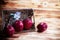 Two apples and dried flowe put in woven basket,beside blurred red apple on wooden timber board