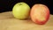 Two apples rotate 360 degrees on a wooden stand