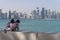 Two Arabian Middle Easter Little Child Girls Sitting on Corniche Broadway and Looking on the Doha Skyline View. Qatar