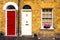 Two arch doors red and white. Typical British front of the house entrance. Exterior of old house with flowers and plants