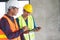 Two architect look at document and planning to renovation room. selective focus on hand pointing clipboard