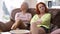 Two argued Caucasian adult women sitting on couch with crossed hands and looking at each other turning. Portrait of