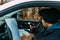 Two armed bandits sitting in a car planning their next robbery, while counting on a stopwatch the time they have for the robbery,