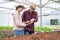 Two Asia farmers inspecting the quality of organic vegetables grown using hydroponics.