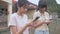 Two Asian adorable teen girls wears earphones enjoy chatting message and watching social media online on smartphone.