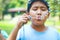 Two Asian boys blowing bubbles in the garden