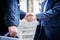 Two asian business have handshake with building and city background.