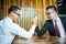 Two Asian businessman expressed a serious expression and fighting by used arm wrestling on wood table.