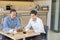 Two Asian businessmen discussing while having coffee together