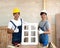 Two Asian carpenters proudly present the newly assembled window in his workshop