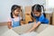 Two asian child girls helping parents put on stuff into the box on moving day.