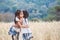 Two asian child girls hugging each other and playing together in the barley field