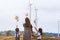 Two asian child girls and their mother playing with wind turbine toy together in the wind turbine field