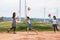 Two asian child girls and their mother are running and playing with wind turbine toy together in the wind turbine field