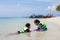 Two asian child girls wearing life jacket playing water in the beautiful sea together with fun in summer vacation