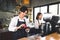 Two asian coffee waitress making cup of hot coffee latte in coffee shop cafe. Barista working with coffee machine in shop