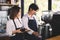 Two asian coffee waitress making cup of hot coffee latte in coffee shop cafe. Barista working with coffee machine in shop