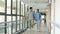 Two asian colleagues walking talking in hallway of hospital
