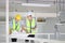 Two Asian contracting engineers wearing safety equipment while inspecting and discussing over the future expanding business plan o