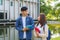 Two Asian couple university students walking and talking to class in walkway on a beautiful sunny day in campus