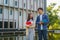 Two Asian couple university students walking and talking to class in walkway on a beautiful sunny day in campus