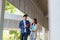 Two Asian couple university students walking and talking to class in walkway on a beautiful sunny day in campus