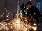 Two Asian engineer wearing a mechanic jumpsuit, safety eyeglasses, and gloves working carefully in a workshop of a factory. Senior