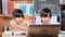 Two Asian female students study online video call Zoom with laptop at home. Two little girls learning at home during quarantine. N