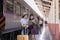 Two Asian female tourist friends are at the train station. Waiting for the train to travel to the provinces together on