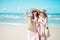 Two Asian girls are relaxing, taking pictures, playing on the beach