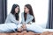 Two Asian Lesbian women in bedroom. Couple people and Beauty concept. Happy lifestyles and home sweet home theme. Cushion pillow