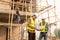 Two Asian male engineers shaking hands and working together Hope stands on the architectural construction