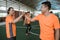 Two Asian male futsal players cheer up with their arms