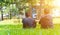Two asian man friends sitting on green grass in the park, encouraging, comforting his friend and looking in the same direction