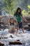 Two asian siblings playing splash water on the waterfall together with fun.