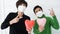 Two Asian woman friends wearing mask with heart balloon support and encourage people form Covid-19 pandemic