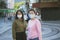 Two asian woman wearing protection mask standing at bangkok city street