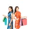 Two Asian women in Chinese qipao traditional dress holding shopping bags, Chinese new year or shopaholic girls concept