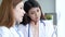 Two asian women doctors discuss meeting doctor`s office medical clinic looking x-ray film consulting patient disease. Asian medica