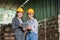 two Asian women factory workers stand using a tablet together