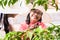 Two Asian women harvesting together organic red fruits