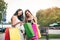Two asian women standing at outlet mall and looking inside shopping bags paper.