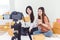 Two Asian women using digital video camera for recording and presenting new product advertisement. Vlog and influencer concept.