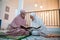 two Asian women wearing Muslim clothes reciting the Quran