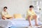 Two Asian young upset unhappy stressed depressed sad teenager male gay men lover couple partner sitting in different corners on