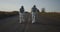 Two astronauts walking on road
