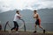 Two athletes with barbell disc making lunges in outdoor workout