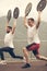 Two athletes with barbell disc making lunges in outdoor workout